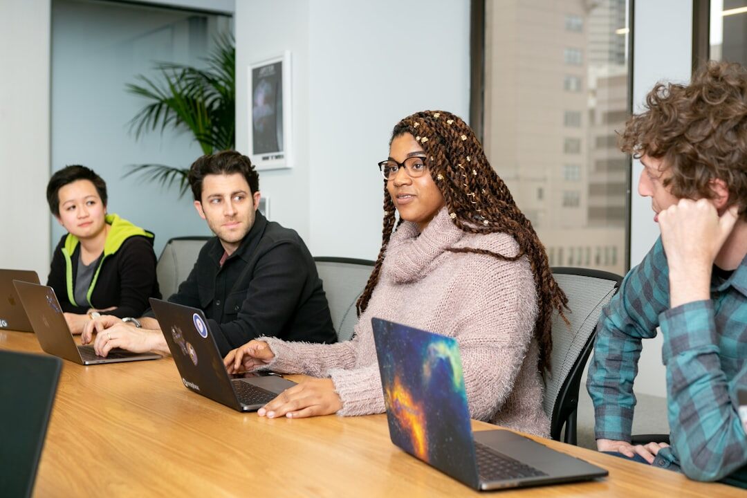 Group of professionals collaborating around laptops in a training workshop